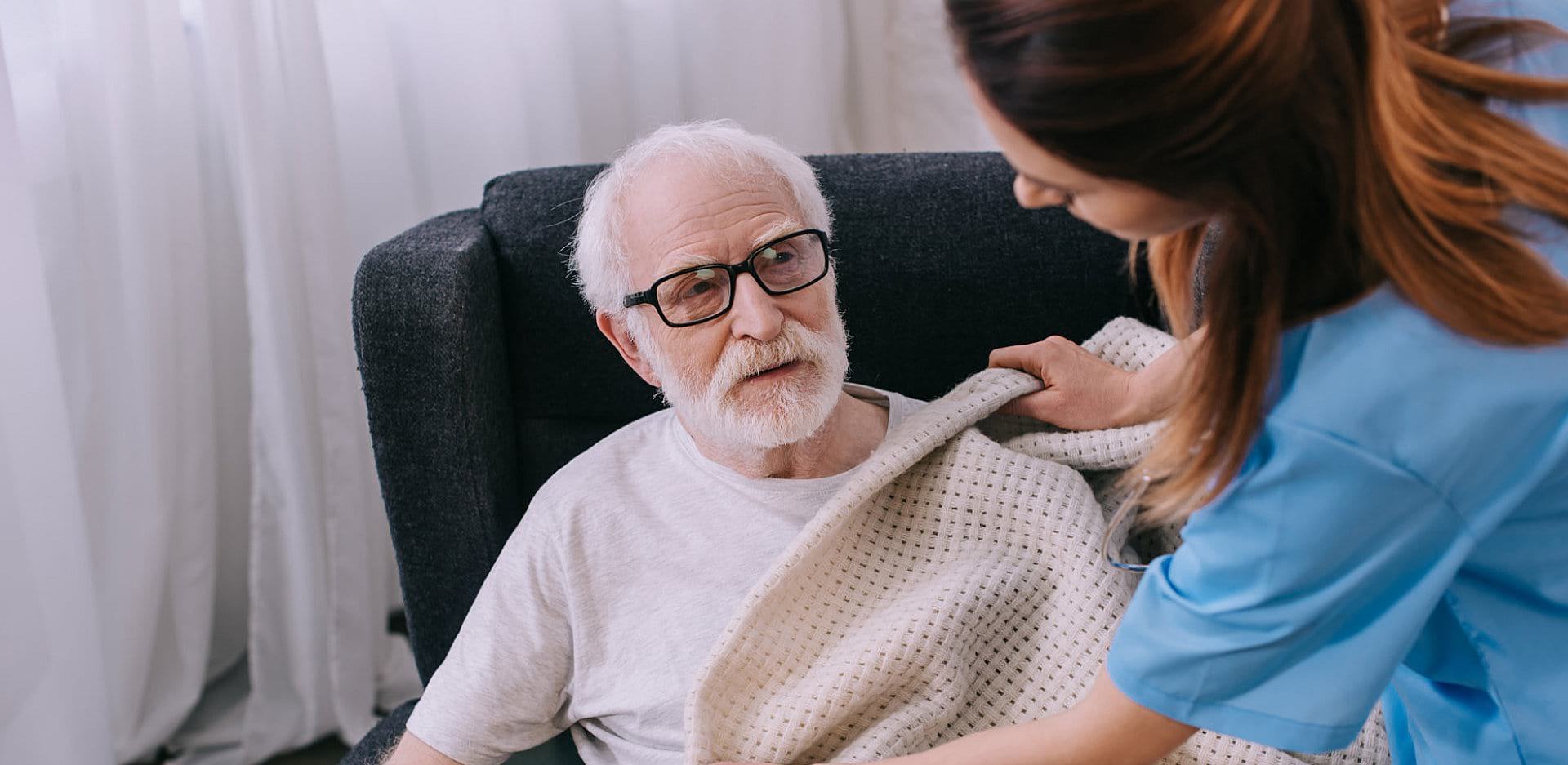 senior and caregiver smiling each other